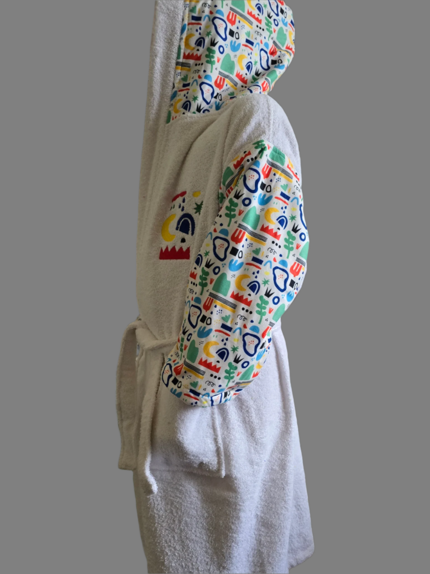 White kids' bathrobe with nature-inspired print, made from soft and absorbent Turkish cotton for comfort and warmth after bath time or swimming lessons.